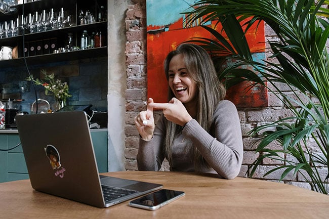 A user doing sign language to another user through a website screenshare